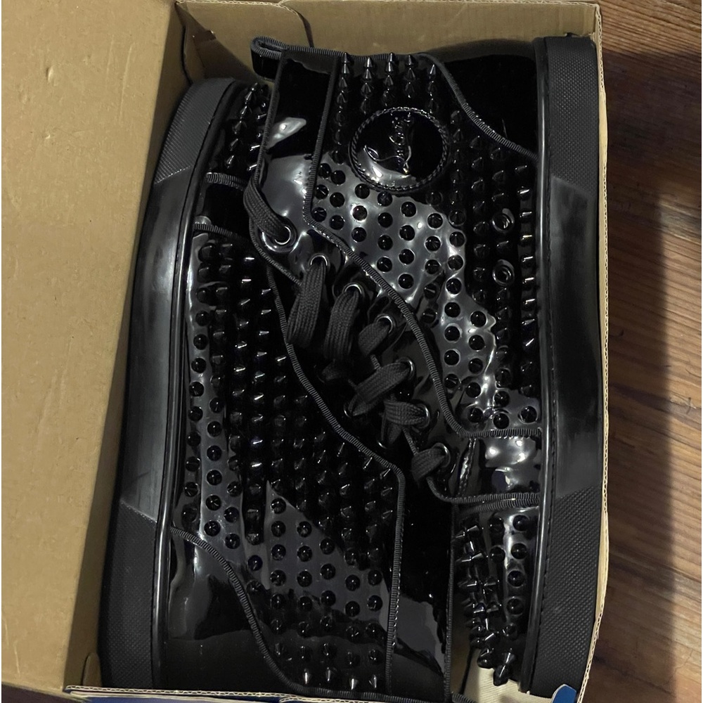 Cristian Louboutin’s spike Patent Leather red bottom sneakers.